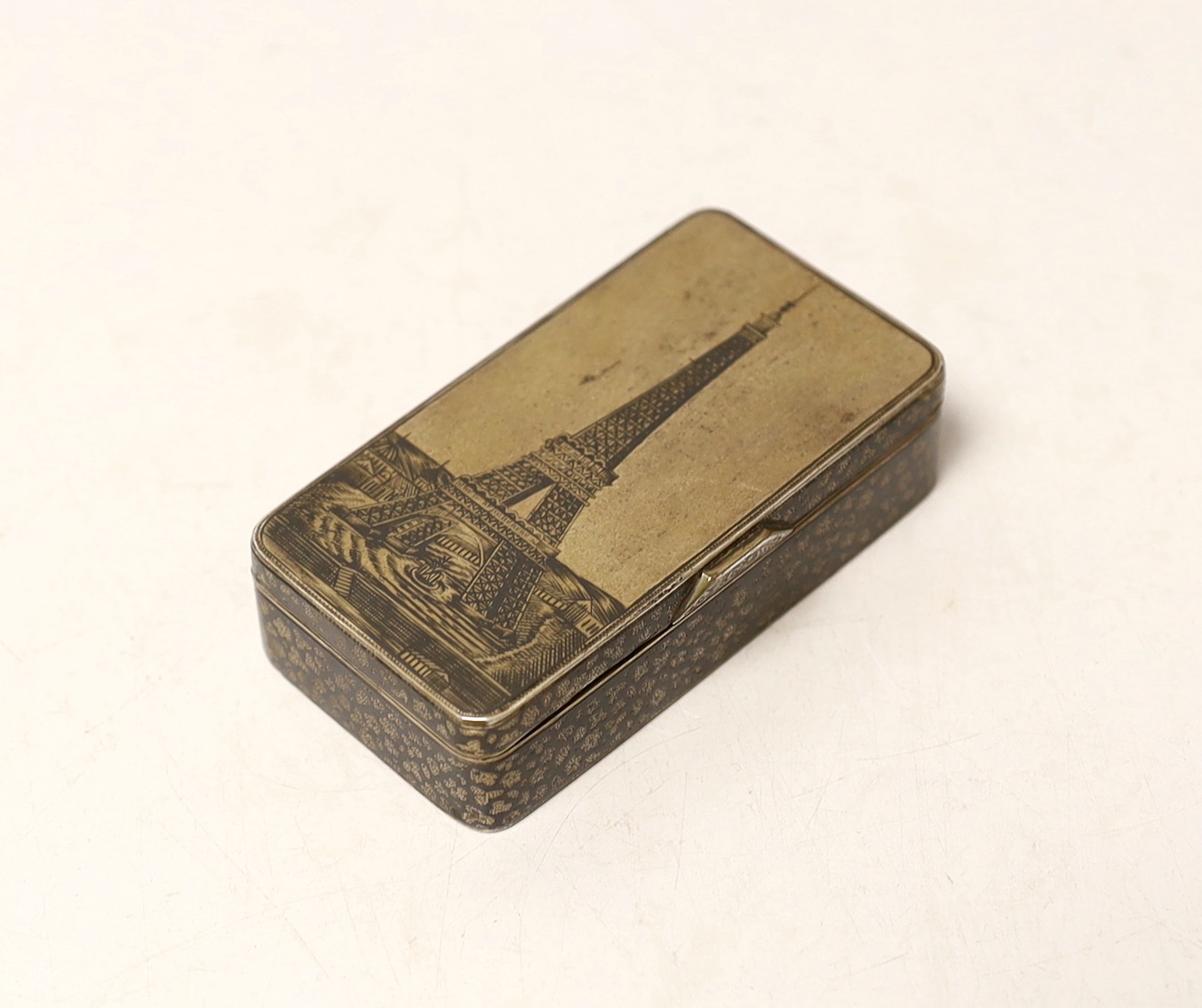 A late 19th century Russian 84 zolotnik and niello rectangular snuff box, the cover decorated with the Eiffel Tower, assay master Lev Oleks?, 1889, (hallmarked for the year the Eiffel Tower opened), 76mm